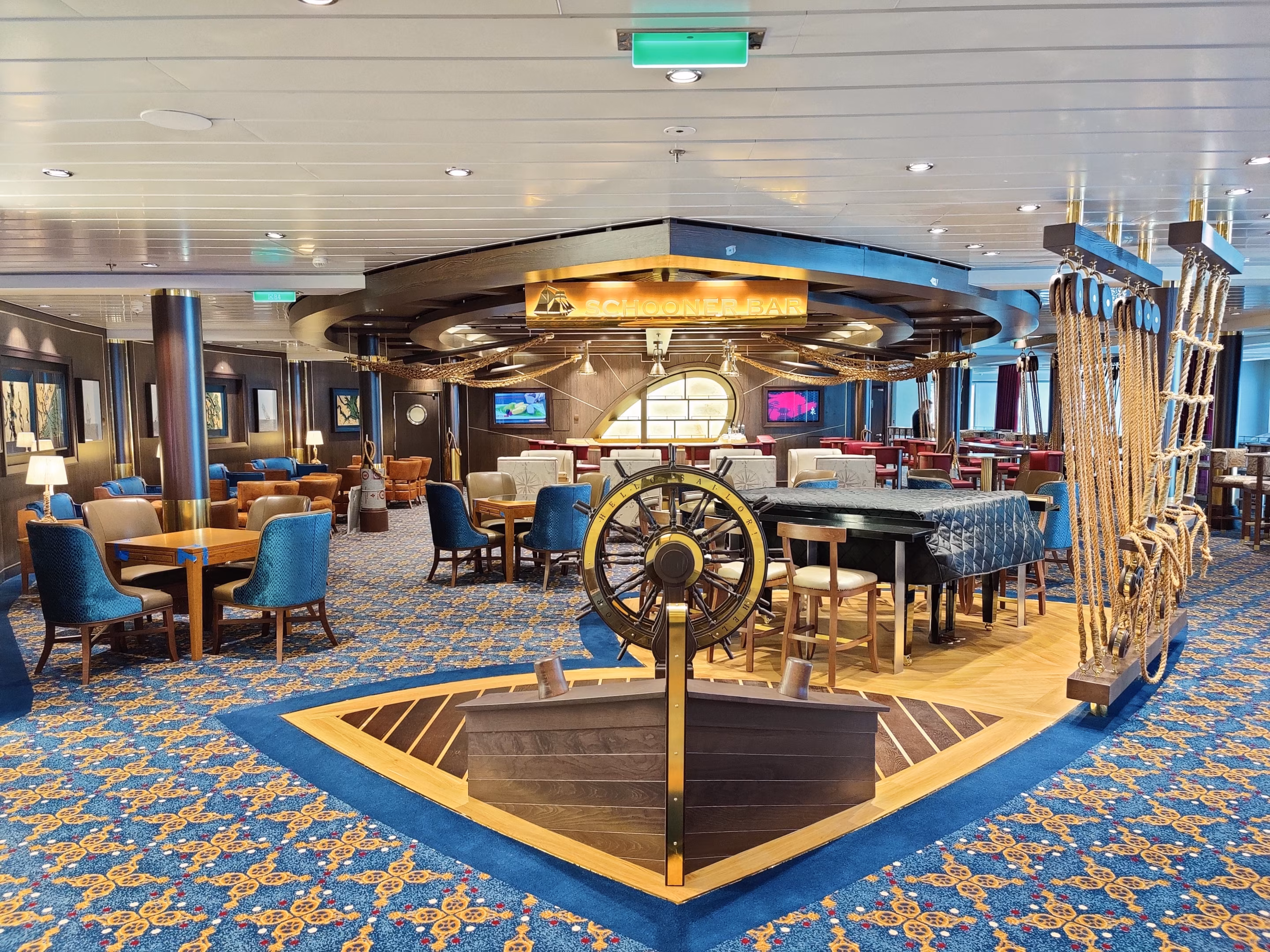 Die Schooner Bar der Odyssey of the Seas mit gemustertem Teppichboden und Steuerrad